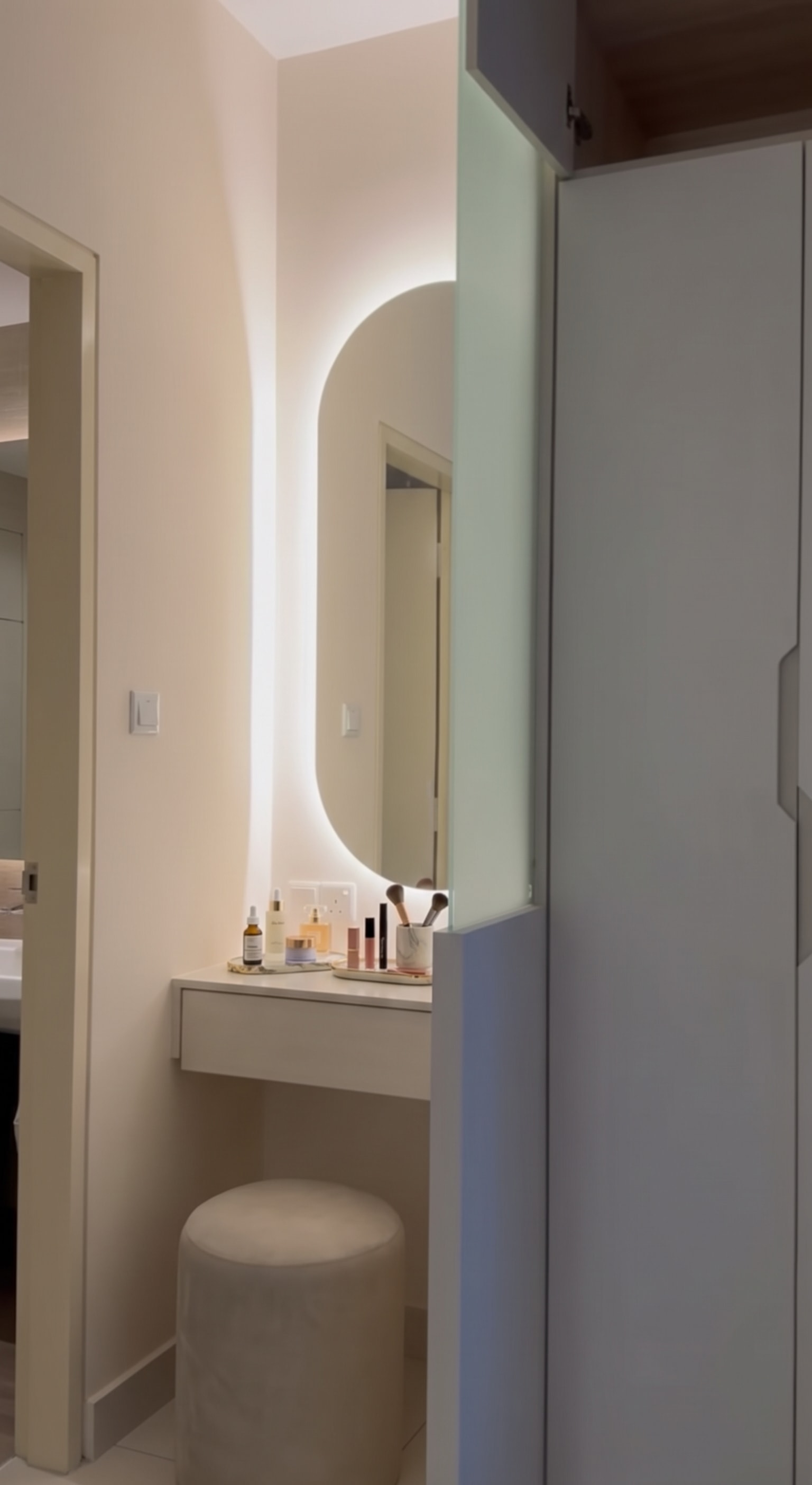 Built-in round LED backlit mirror integrated into wardrobe run with dressing table