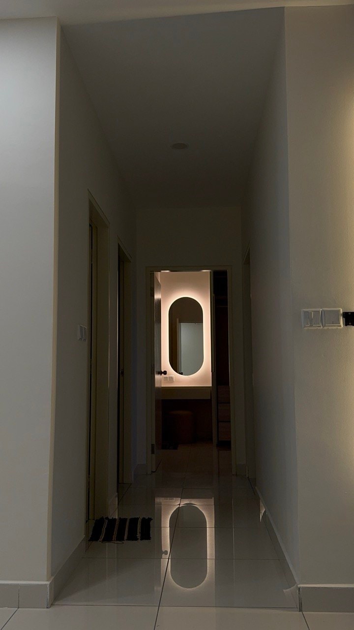 Hallway corridor with oval LED mirror glow visible through bedroom doorway at night
