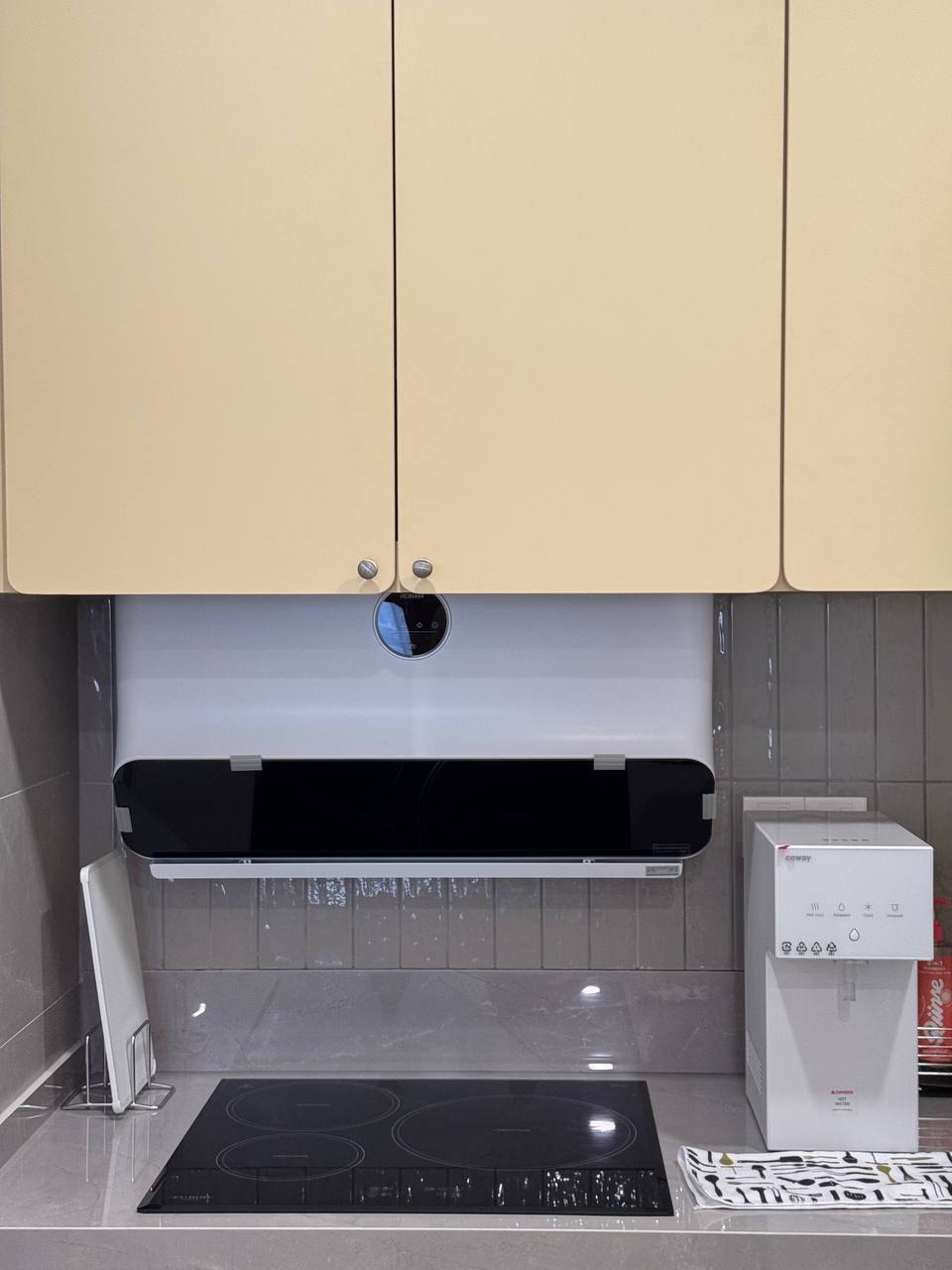 Butter-yellow upper cabinets with induction hob and hood