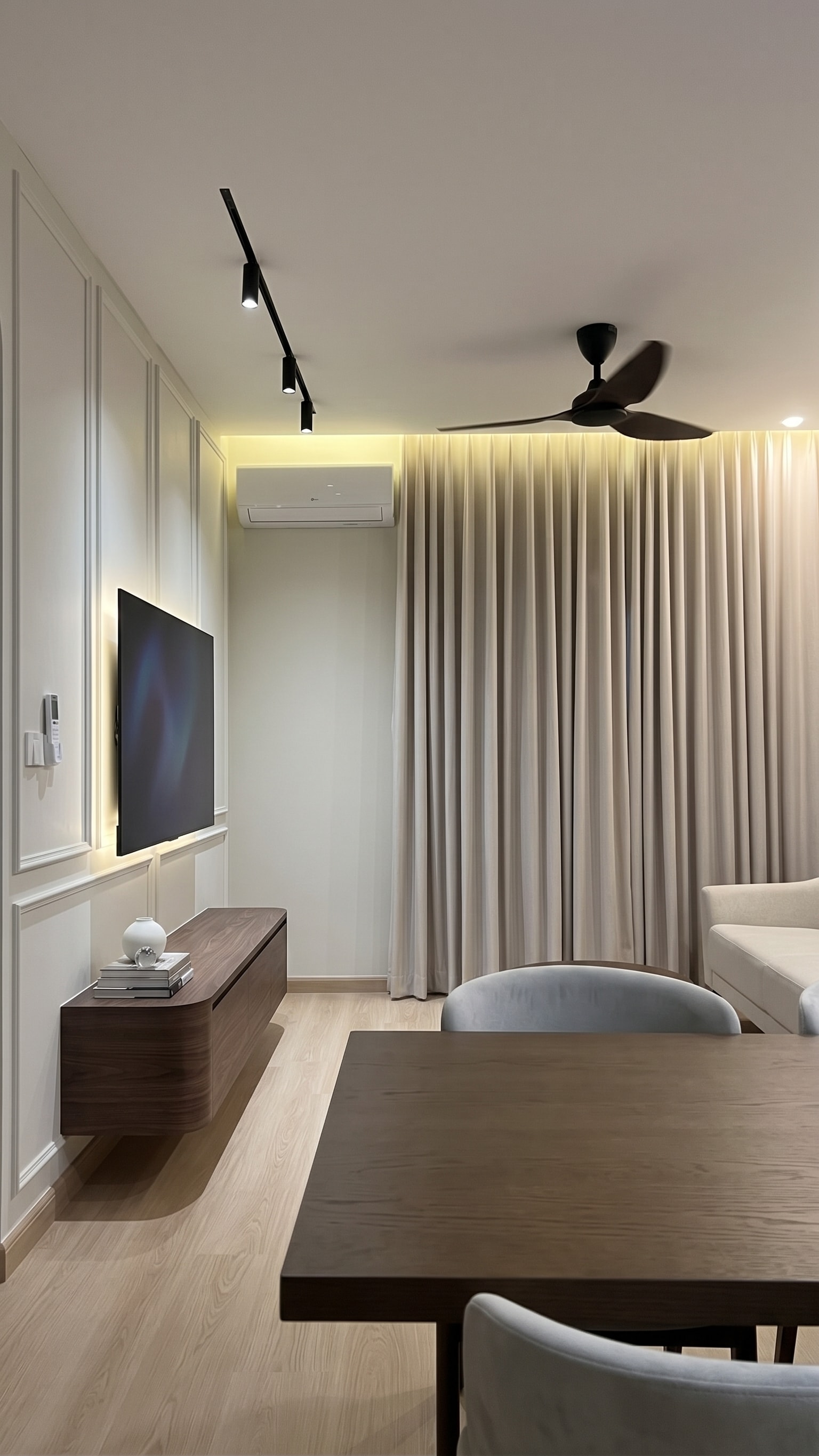 Living area with wainscotting TV feature wall, floating walnut console and floor-length curtains