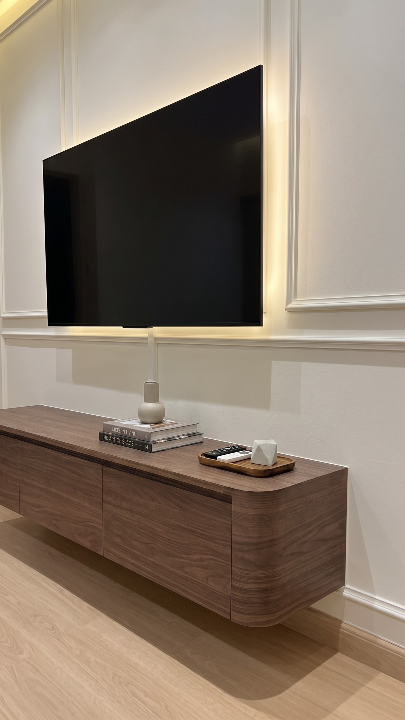 Floating walnut TV console close-up with wainscotting panel and warm LED backlight