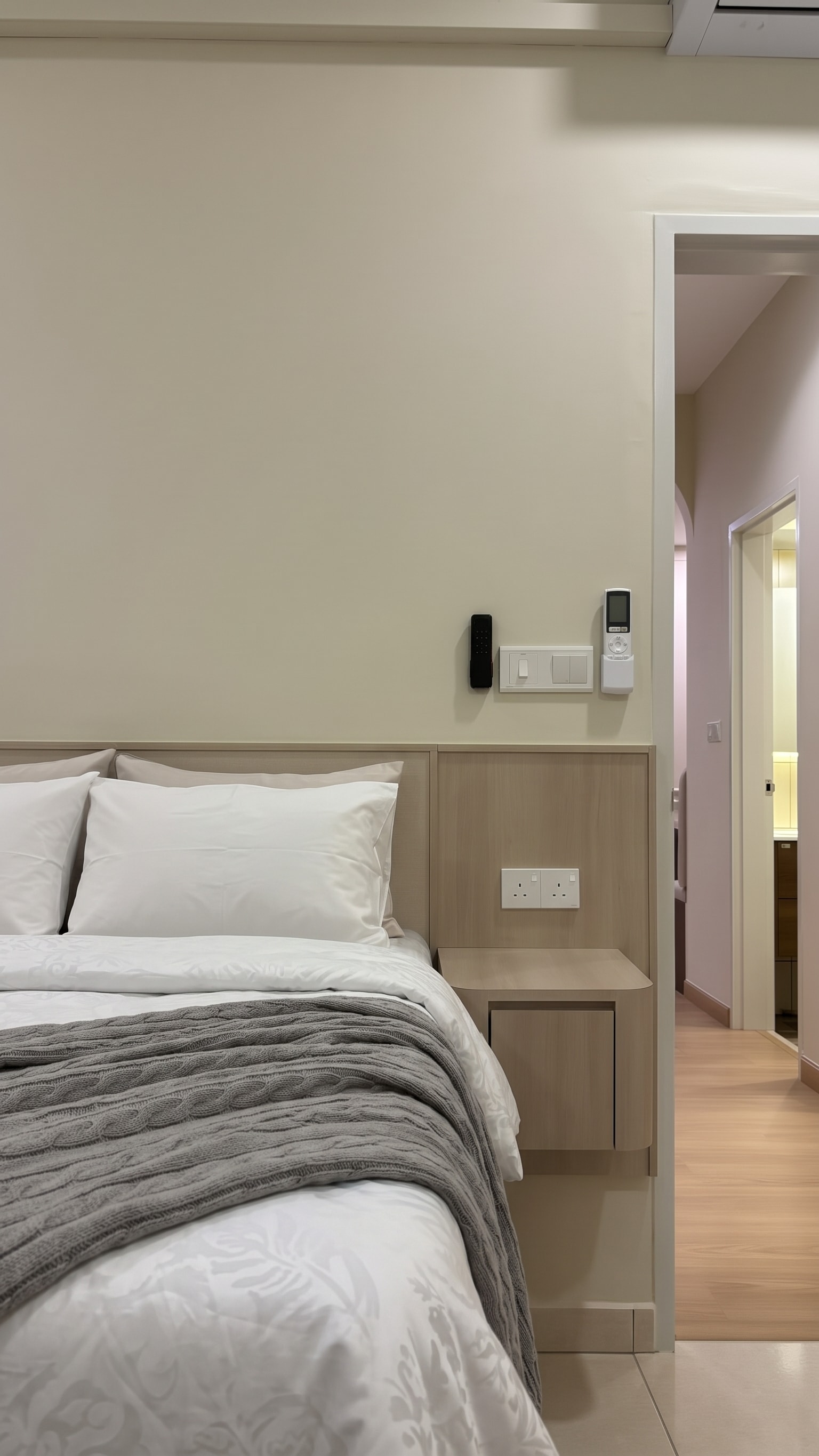 Master bedroom with light wood headboard panel and integrated bedside shelf with power points